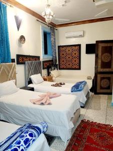 a hotel room with three beds in a room at Dar Berrada-Ziat in Fès