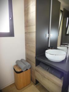 a bathroom with a sink and a trash can at Cottage chaleureux avec Sauna & Jacuzzi in Saint-Coulitz