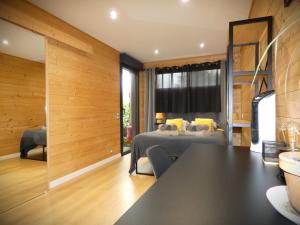 a living room with a table and a bed in a room at Cottage chaleureux avec Sauna & Jacuzzi in Saint-Coulitz