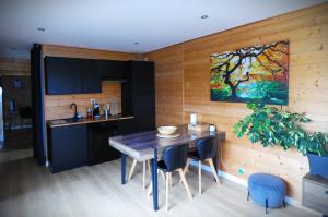 a kitchen with a table and a painting on the wall at Cottage chaleureux avec Sauna & Jacuzzi in Saint-Coulitz +36 photos