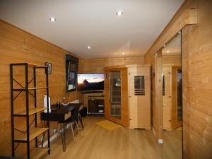 a room with wooden walls and a table and a desk at Cottage chaleureux avec Sauna & Jacuzzi in Saint-Coulitz