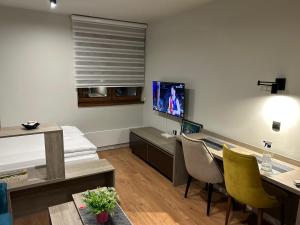 a room with a bed and a desk with chairs at Apartman Snezni Vrh - Bela Reka, Brzece in Brzeće