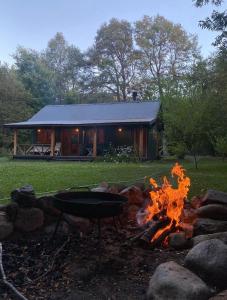 un foyer devant une cabane en rondins dans l'établissement Casa Don Enrique Quila Quina, à San Martín de los Andes