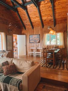 un salon avec un canapé et une salle à manger dans l'établissement Casa Don Enrique Quila Quina, à San Martín de los Andes