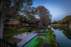 a view of a river with a table and chairs on a dock at Waterfront Dock Fire Pit Book for Wurstfest Family in McQueeney