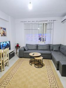 a living room with a couch and a table at Kasim Cozy Apartment- N&S Terminal in Bregu i Lumit