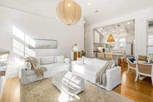 Il comprend un salon doté d'un mobilier blanc et une salle à manger. dans l'établissement Barefoot Bungalow by Stay on 30a, à Seagrove Beach