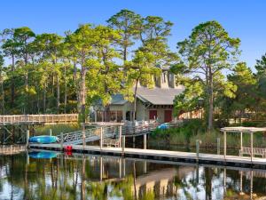 une maison avec un quai et un bateau sur l'eau dans l'établissement Barefoot Bungalow by Stay on 30a, à Seagrove Beach