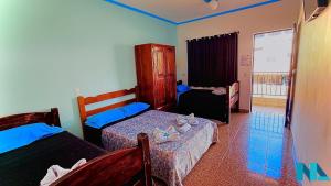 a bedroom with two beds and a window at Nova Aliança Suítes por Temporada em Amparo NÃO SOMOS POUSADA in Amparo