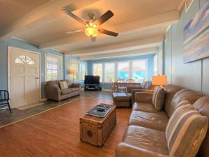 a living room with a couch and a ceiling fan at Foster's Ocean View in Edisto Island +40 photos