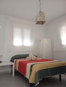 a bedroom with a bed with a red and white blanket at Habitación en casa compartida "Al-Mariya" in Almería