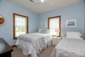 Duas camas num quarto com paredes e janelas azuis em Sound Choice em Edisto Island