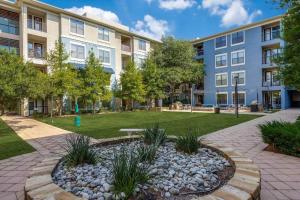 an apartment building with a park in front of it at Centrally-Located 1BR Suite with Resort Pool View in Frisco