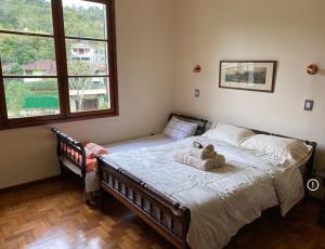 a bedroom with a bed with a stuffed animal on it at Casa Vale da Serra - Petrópolis in Petrópolis +21 photos