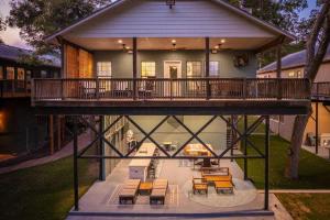 ein großes Haus mit einer Terrasse mit Tischen und Bänken in der Unterkunft Lakefront Dock & Fire Pit Book with Family for Wurstfest Now in McQueeney
