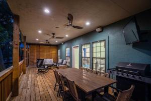 eine große Terrasse mit einem Holztisch und Stühlen in der Unterkunft Lakefront Dock & Fire Pit Book with Family for Wurstfest Now in McQueeney