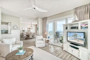 HP 36W Condo by 30A Escapes في روزماري بيتش: غرفة معيشة مع تلفزيون بشاشة مسطحة وطاولة