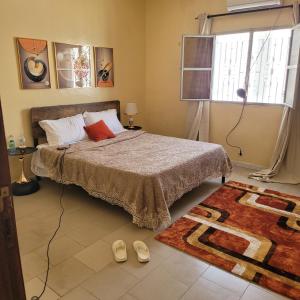 a bedroom with a bed and a pair of shoes at Residence Ganou Mboro in Mboro +7 photos