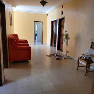 een woonkamer met een rode stoel en een tegelvloer bij Ganou Mboro in Mboro