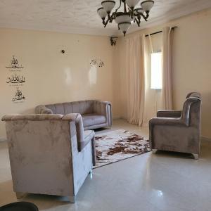 een woonkamer met 2 stoelen en een bank bij Ganou Mboro in Mboro