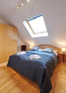 um quarto com uma cama com lençóis azuis e uma clarabóia em DAS BURGENNEST, Bademantelgang zur Therme Lutzmannsburg, Garten, Parkplatz, Verpflegung auf Anfrage em Lutzmannsburg