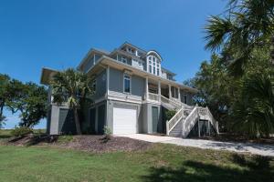 una casa grande con una palmera delante de ella en Moonrise Point, en Edisto