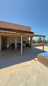 a large patio with a building with a roof at AP 104 com Piscina e Churrasqueira - Canoas Flecheiras in Trairi