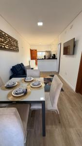 a dining room and living room with a table and chairs at AP 104 com Piscina e Churrasqueira - Canoas Flecheiras in Trairi
