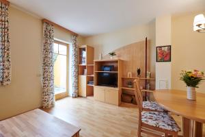uma sala de estar com uma mesa de jantar e uma televisão em DAS BURGENNEST, Bademantelgang zur Therme Lutzmannsburg, Garten, Parkplatz, Verpflegung auf Anfrage em Lutzmannsburg mais 15 fotografias