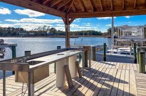 a pool table on a dock next to the water at Waterfront condo at Harbor Landing G02 - Relax in BEAUTIFUL Ocean Springs in Gulf Park Estates