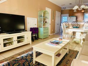 a living room with a flat screen tv and a table at 123 Beau Clair - Beachside Townhome with Balcony and Pool in Long Beach in Long Beach