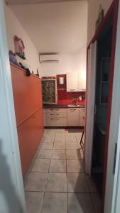 kuchnia z czerwono-białymi szafkami i podłogą wyłożoną kafelkami w obiekcie MARGHEhouse w mieście Passo Oscuro