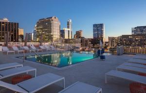 uma piscina no último piso com cadeiras e um horizonte da cidade em Club Wyndham Austin em Austin