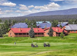 a golf course with two golf carts on a green at Club Wyndham Pagosa in Pagosa Springs