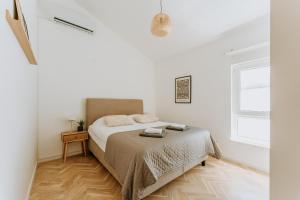 ein weißes Schlafzimmer mit einem Bett und einem Fenster in der Unterkunft Boutique Apartments Old Town in Mostar