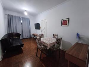 a living room with a table and chairs and a television at Apto/garagem coberta/900m-Centro in Registro +25 photos
