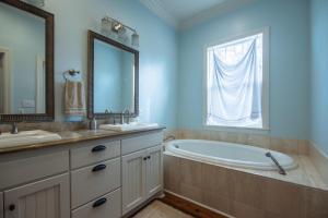 a bathroom with a tub and a sink and a mirror at Misty Lane in Edisto Island +38 photos
