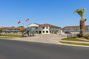 eine Straße vor einem Gebäude mit einer Palme in der Unterkunft HomeTowne Studios by Red Roof San Antonio E - Frost Bank Center in San Antonio
