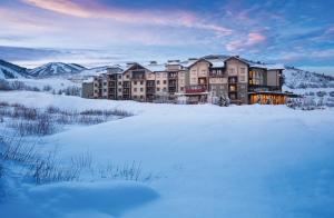 a large building in the snow with mountains in the background at Club Wyndham Park City in Park City