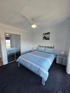 ein Schlafzimmer mit einem Bett und einem Deckenventilator in der Unterkunft Hydra 2 bedroom Holiday Unit in Merimbula + 12 Fotos