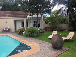 a house with a swimming pool and a vase in the yard at Harbour views in Athenree