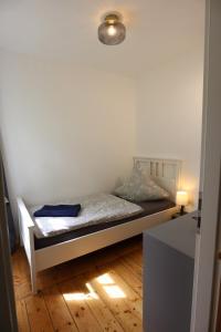 a small bedroom with a bed with a light at Gemütliches Schmuckstück mit zwei Schlafzimmern in Mügeln