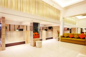 eine Lobby mit einem gelb-orangenen Sofa in der Unterkunft Citypoint Hotel in Bangkok