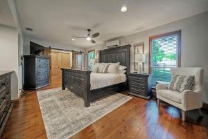 a bedroom with a bed and a dresser and a chair at Waterfront Sleeps 16 Perfect for Family & Wurstfest in McQueeney