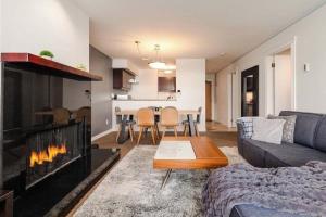 uma sala de estar com um sofá e uma lareira em Whistler Village Retreat, Private Hot Tub & Sauna em Whistler