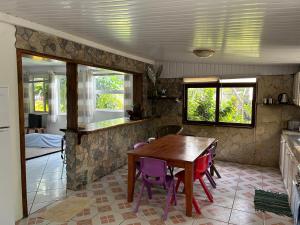 a kitchen with a wooden table and purple chairs at Ave Surfing House in Mahina