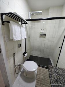 a bathroom with a toilet and a shower with towels at Excelente apartamento com vaga garagem a 50 metros da orla da Praia do Morro Guarapari in Guarapari +17 photos