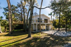 a house with a balcony and a tree at Turtle Time in Edisto Island