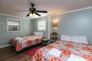 a bedroom with two beds and a ceiling fan at Turtle Time in Edisto Island