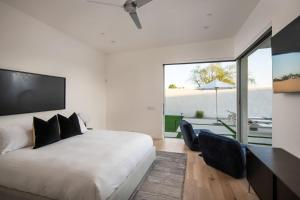 a bedroom with a white bed and a large window at Oxygen @ Elemento49 Pool Spa Sleeps 16 in Desert Groves Mobile Home Park +33 photos